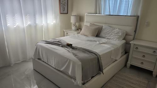 a bedroom with a white bed and a night stand at My Relaxing place! in North Fort Myers