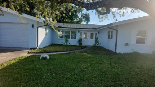 a white house with a tree in the yard at My Relaxing place! in North Fort Myers