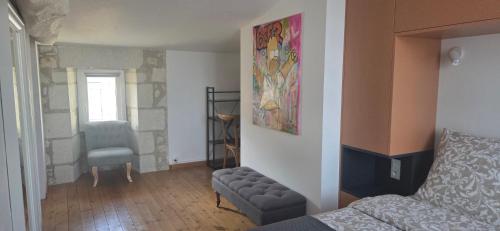 ein Schlafzimmer mit einem Bett und einem Stuhl in einem Zimmer in der Unterkunft La Demeure des Artistes - Quartier historique in Saintes