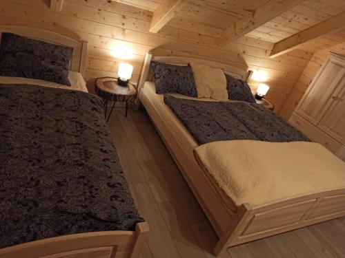 a bedroom with two beds in a log cabin at chata Malina in Martin