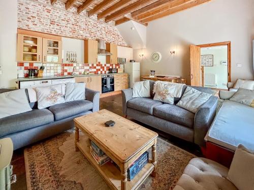 a living room with two couches and a table at Kingfisher Oast in Hollingbourne