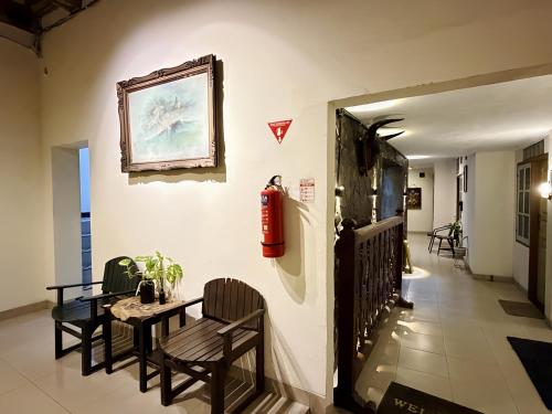 a hallway with a table and chairs and a fire extinguisher at The Raden Patah Heritage Kota Lama Semarang in Semarang