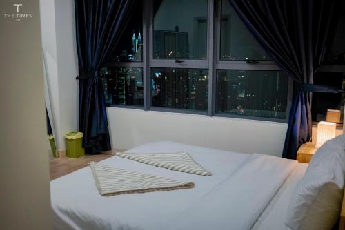 un lit blanc dans une chambre avec une fenêtre dans l'établissement Arte Plus Jalan Ampang with KLCC View, à Kuala Lumpur