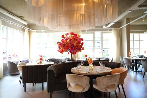 a restaurant with tables and chairs and a large chandelier at Hotel Alkmaar - Bar & Restaurant in Alkmaar