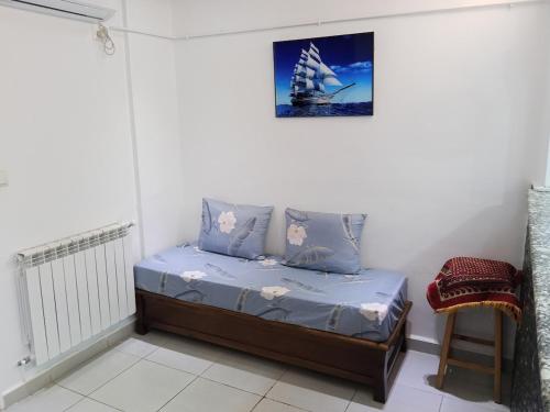 een slaapkamer met een bed met een zeilboot aan de muur bij Houcine appartement in 'Aïn el Turk
