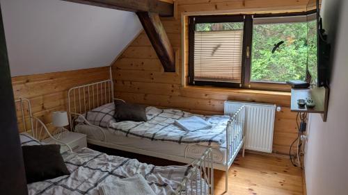 een slaapkamer met twee bedden en een raam bij Chata z Widokiem in Międzybrodzie Bialskie