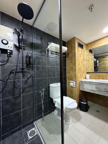 a bathroom with a shower with a toilet and a sink at Trigo Hotel Kuala Lumpur in Kuala Lumpur