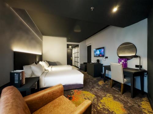 a hotel room with a bed and a desk at Trigo Hotel Kuala Lumpur in Kuala Lumpur