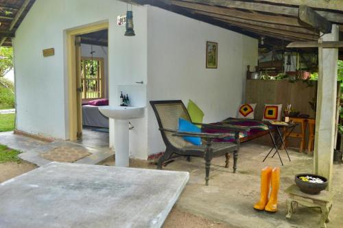 een woonkamer met een stoel en een wastafel bij EcoBlueprint Garden in Pannala