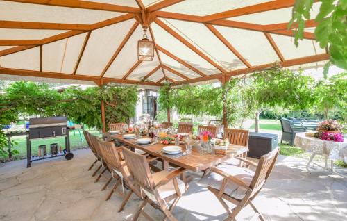 una gran mesa de madera y sillas en un patio en Lake Front Home In Arezzo Ar, en Antria