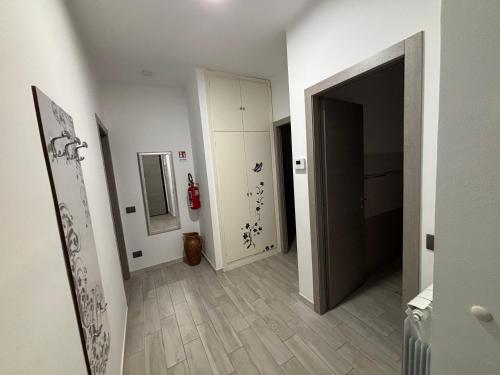 塔贾Appartamento Le Palme的一条带白色墙壁和木地板的走廊和一扇门