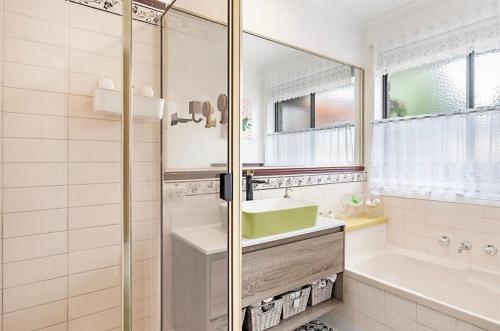 a bathroom with a shower and a sink and a tub at Home of Susan Close in Narre Warren