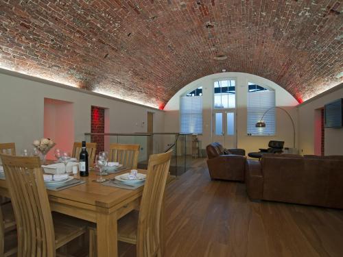 a dining room and living room with a brick ceiling at The Sergeants Quarters, Golden Hill Fort in Freshwater