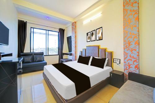 博帕尔Super Hotel O York Residency的一间酒店房间，里面有一张床和一张沙发