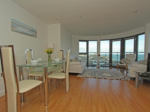 een woonkamer met een glazen tafel en een bank bij 10 Horizons in Newquay