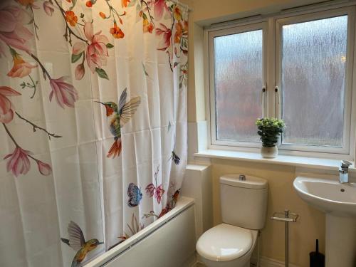 ein Badezimmer mit Toilette und Duschvorhang mit Schmetterlingen in der Unterkunft Warm & Cosy 4 Bed Cambridge House w Parking Garden & High Speed WIFI in Milton