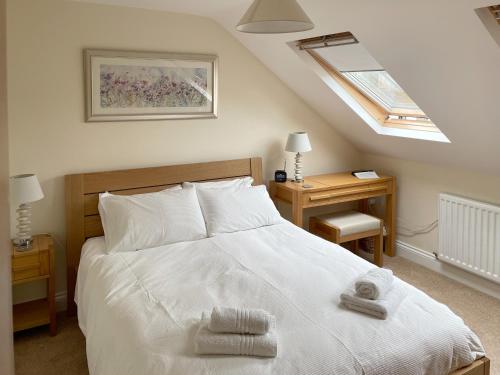 a bedroom with a white bed with two towels on it at The Old Laundry 3 in Keswick