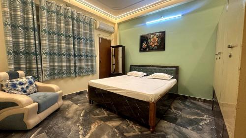 a bedroom with a bed and a couch and a chair at Varanasi Bliss Stay in Varanasi