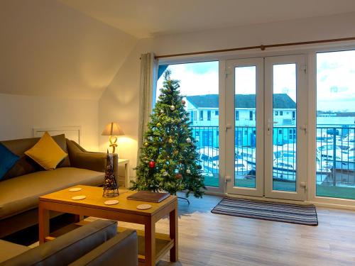a living room with a christmas tree in the living room at Heron in Wroxham