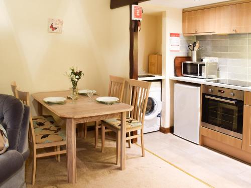 a small kitchen with a wooden table and chairs at Willow Cottage in Ambleside