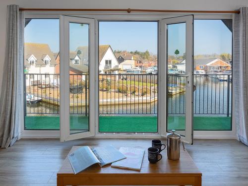 a room with a large window with a view of a yard at Coot in Wroxham
