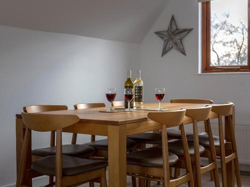 a wooden table with wine glasses and a star on the wall at Coot in Wroxham