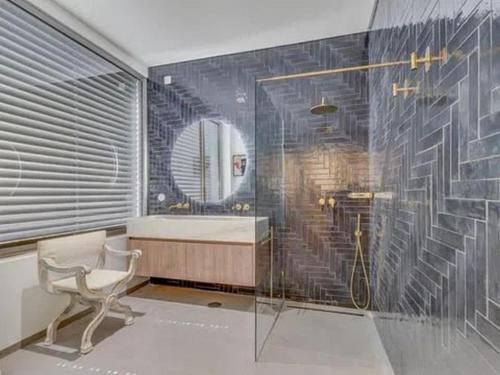 a bathroom with a shower and a tub and a chair at Super apartamentos para qualquer um de Silva in Paço de Arcos