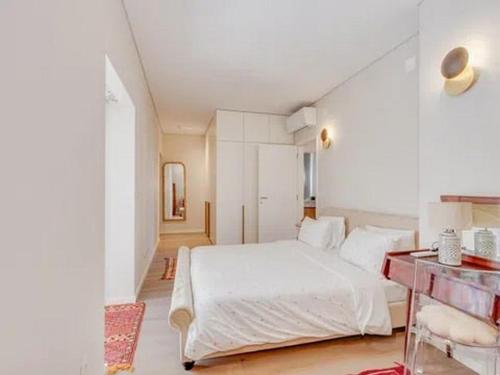 a white bedroom with a large white bed in it at Super apartamentos para qualquer um de Silva in Paço de Arcos