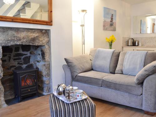 a living room with a couch and a fireplace at Salty Cottage in Newlyn