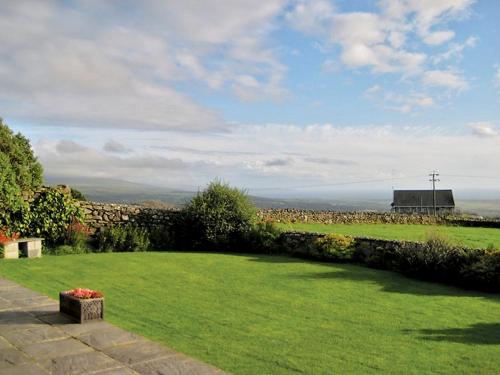 a garden with green grass and a stone wall at Rhiwgoch - Hw7449 in Harlech