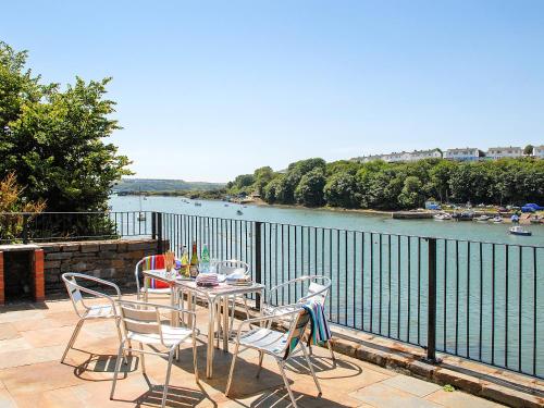 Una mesa y sillas en un patio con vista a un río. en Kingfisher-Qc1185, en Milford Haven