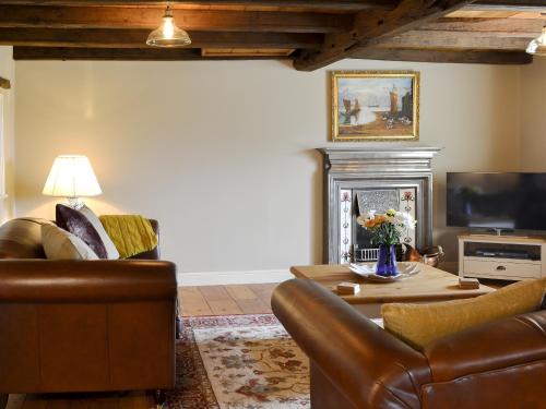 a living room with leather furniture and a fireplace at Westfield Farm Uk33124 in Kirby Misperton