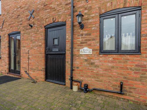 Runcton HolmeにあるPurlin Barn - E3867のレンガ造りの建物(黒いドア、窓付)