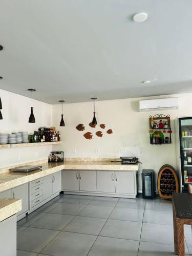 a kitchen with white cabinets and a counter top at Chalé Murici Lençóis in Santo Amaro