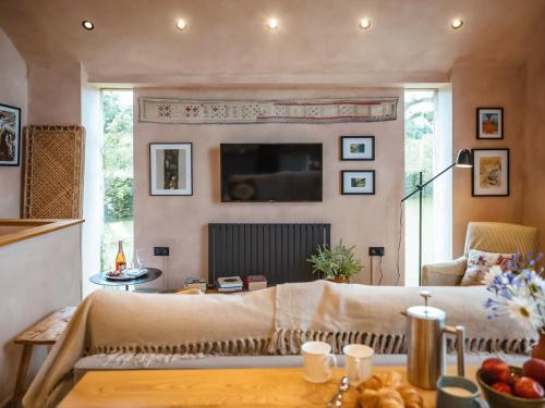 a living room with a couch and a tv at Olive in Kelsall