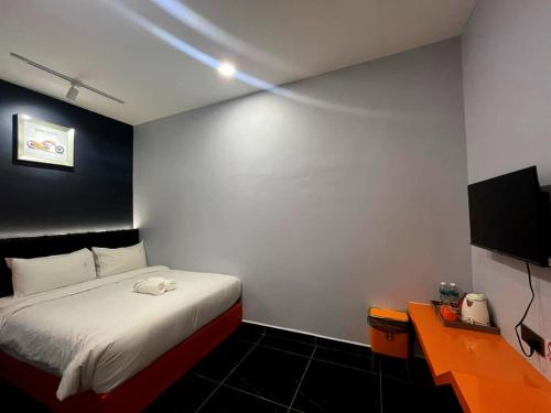 a bedroom with a bed and a desk and a television at Eng Wan Hotel in Kamunting