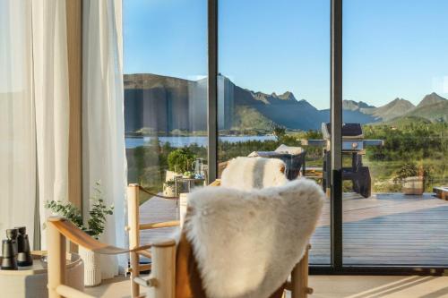 LyngværetにあるLofoten Arctic Lodge - sea view, jacuzzi & saunaの窓際の椅子付きの部屋