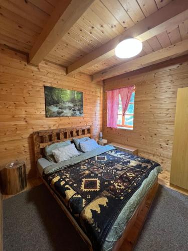 een slaapkamer met een bed in een blokhut bij Plitvice Waterfall Millhouse Challet Stipanov Mlin in Plitvička Jezera
