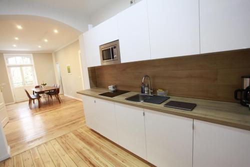 a kitchen with white cabinets and a wooden counter top at Ferienhaus Alter Bahnhof Stötteritz in Leipzig