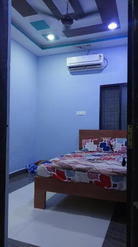 Un dormitorio con una cama en una habitación azul. en karthikfamilyguesthouse, en Hampi