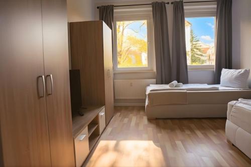 ein kleines Schlafzimmer mit einem Bett und einem Fenster in der Unterkunft Ruhiges 5-Personen Apartment mit kostenlosen Parkplätzen, Boxspringbetten, WLAN, 3x TV, vollausgestatteter Küche 