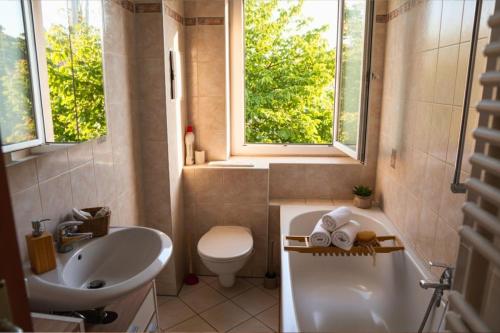 ein Badezimmer mit Waschbecken, Toilette und Badewanne in der Unterkunft Ruhiges 5-Personen Apartment mit kostenlosen Parkplätzen, Boxspringbetten, WLAN, 3x TV, vollausgestatteter Küche 