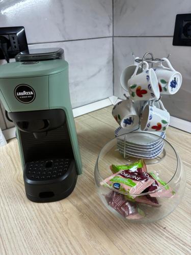 a green coffee maker sitting next to a plate of food at ScaLOVEa in Scalea