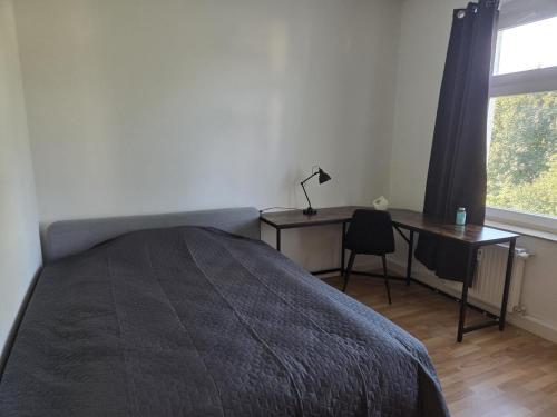 a bedroom with a bed and a desk and a window at Große, moderne, helle Unterkunft mit Essküche all-in LTE in Gera