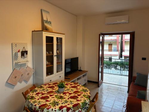 a living room with a table with a flowered table cloth at ScaLOVEa in Scalea