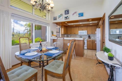 a dining room and kitchen with a table and chairs at 412 Ridge in Kahana