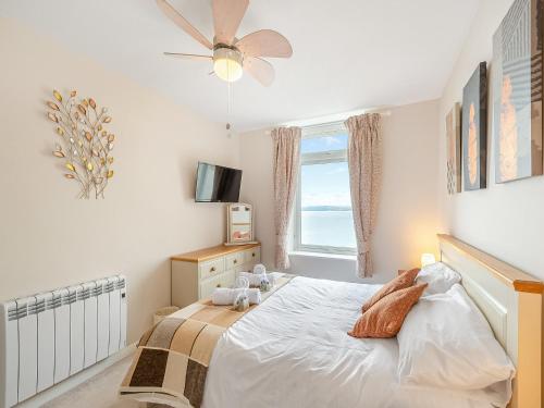 a bedroom with a white bed and a window at Boohay - Bay Fort in Torquay