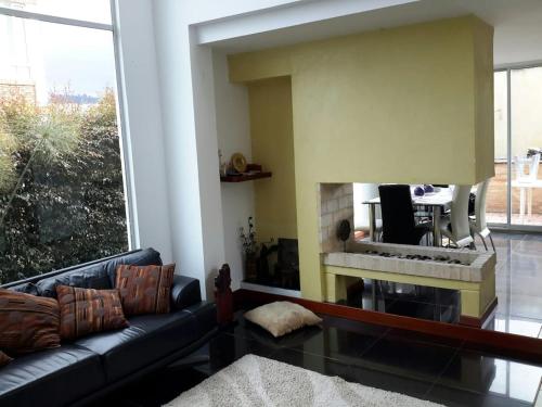 ein Wohnzimmer mit Couch und Kamin in der Unterkunft Casa Blanca in Cajicá