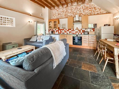 a living room with a couch and a table at Kingfisher Oast in Hollingbourne