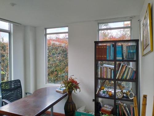 einen Esstisch und ein Bücherregal mit Büchern in der Unterkunft Casa Blanca in Cajicá